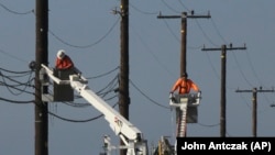 资料照片:美国加州工人正在维修野外输电线(2018年11月25日)