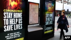 2020年3月31日伦敦市中心行人走过有关冠状病毒的标牌:为拯救生命请呆在家里。