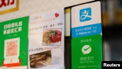 香港一家餐厅外悬挂的阿里巴巴关联公司蚂蚁金服的电子支付服务支付宝,以及腾讯控股所属的微信支付的标示。