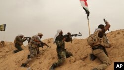 F什叶派民兵巴德尔旅成员同“伊斯兰国”激进分子在安巴尔省费卢杰郊外前线作战。(2015年6月1日)