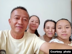 范士贵与妻子及两个女儿在柬埔寨的合影(照片由范士贵提供)。