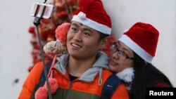 2014年12月24日,一对情侣带着圣诞帽在北京一所教堂里自拍。