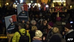 在瑞士苏黎世,人们高举印有美国总统特朗普头像的横幅,抗议他出席达沃斯世界经济论坛。