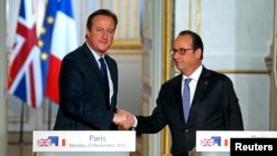英国首相卡梅伦(左)在联合记者会上和法国总统奥朗德握手(2015年11月23日)