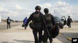 Thành viên của đội phản công của Sở Mật vụ (CAT) đi bộ qua đường băng tại sân bay quốc tế Kortrijk-Wevelgem tại Waregem, Bỉ, ngày 26/3/2014.