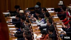 2013年3月5日在人民大会堂召开的第十二届人大开幕式上按钮批准建议草案。(美国之音东方拍摄)