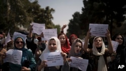 周日,一些阿富汗妇女游行到前妇女事务部附近,要求妇女参与公共生活。