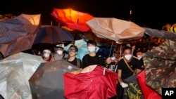 在香港政府总部外面,示威者用雨伞阻挡胡椒喷雾(2014年10月15日)