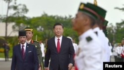 中国国家主席习近平和文莱元首哈桑纳尔苏丹的陪同下检阅文莱仪仗队。(2018年11月19日)