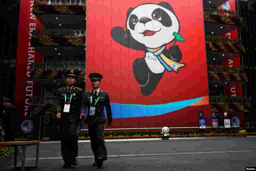 在上海的国家会展中心举行中国国际进口博览会,在吉祥物熊猫前面有保安人员(2018年11月3日)。