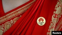 印度一名妇女2019年10月在一次移动电信展销会上佩戴华为5G胸章。