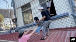 台湾花莲正在从被地震震得歪斜的建筑里救出一名女童。(2024年4月3日)