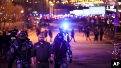 2024年3月22日,俄罗斯莫斯科西部的克罗库斯城音乐厅附近,俄罗斯联邦国家近卫军的军人帮助一名男子离开该地区。