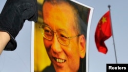 一位抗议者在中国驻奥斯陆大使馆门外举着刘晓波的照片。(资料照)