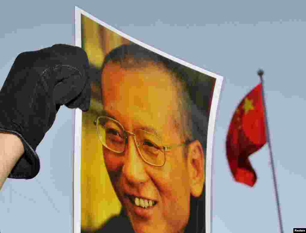 在颁奖典礼的前一天，中国驻挪威大使馆外面，有人手持刘晓波像示威。（2010年12月9日）