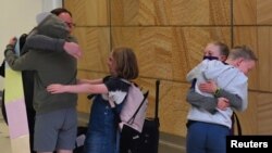 来自新西兰的旅客2021年4月19日在抵达悉尼国际机场时与亲人拥抱团聚(路透社)