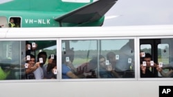 一群寻求庇护者在巴布亚新几内亚的机场降落后出示他们的身份证(资料图)