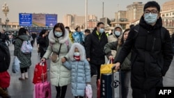 2020年1月21日北京火车站戴着口罩的人群回家过新年。