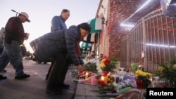 民众在加州蒙特利帕克市发生枪击案的舞厅外摆放鲜花致意(2023年1月23日)