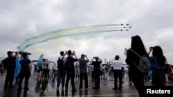 在中国广东珠海市举行的中国国际航空航天博览会(即珠海航展)上,参观者观看中国人民解放军空军八一特技飞行表演队的飞机表演。(2024年11月14日)