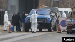 北京房山地区发现非洲猪瘟后,身穿防护服的防疫人员在通往出现疫情的村庄道路上设卡。(2018年11月23日)