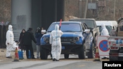 北京房山地区发现非洲猪瘟后,身穿防护服的防疫人员在通往出现疫情的村庄道路上设卡。(2018年11月23日)