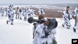 军人们在乌克兰西部的利沃夫附近的亚沃里夫练兵场操练使用NLAW反坦克导弹。(2022年1月28日)