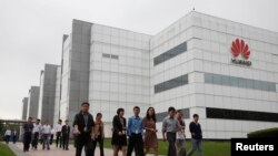 华为技术有限公司的员工走过广东省深圳市的公司办公楼(2012年4月17日)。