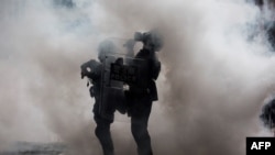 2019年6月12日,在香港政府总部外举行的反对有争议引渡法提案的集会上,警察被催泪瓦斯包围。