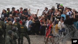 2018年12月10日,在墨西哥蒂华纳的隔离墙附近看到,在圣迭戈,美国警方和边境巡逻队面对一个支持中美洲寻求庇护者的跨信仰团体的成员。