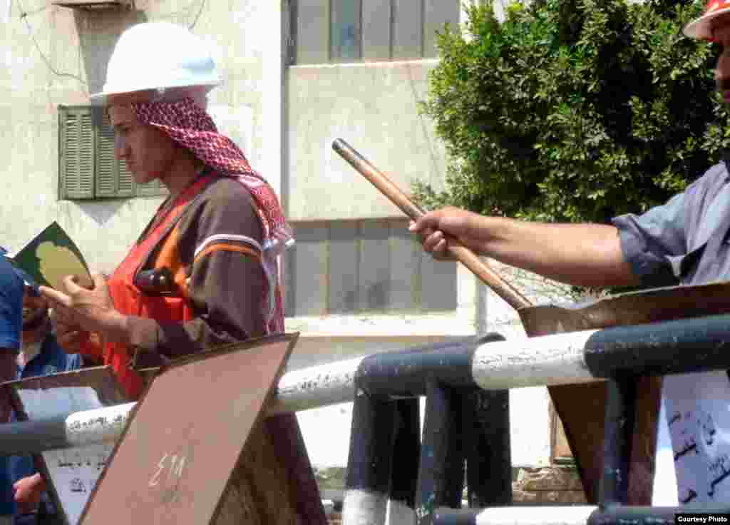 Nhóm Huynh đệ Hồi Giáo cầm kinh Quran và gậy tại chốt kiểm soát an ninh ra vào khu vực của Huynh đệ Hồi Giáo ở bên ngoài đền Rabaa al-Adawiya tại Cairo, 11-7-2013. Ảnh: VOA/Sharon Behn