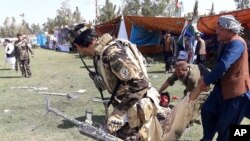 资料照:阿富汗拉什卡尔加地区发生多起爆炸后,人们抬走一名伤员。(2019年3月23日)