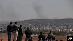 2014年10月15日,民众聚集在土叙边界附近的苏鲁克郊外山头,观看叙利亚库尔德人和伊斯兰国极端分子在叙利亚的科巴尼交战。