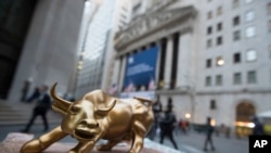 资料: 纽约证交所外面一位摊贩的桌上摆着象征牛市的公牛塑像。