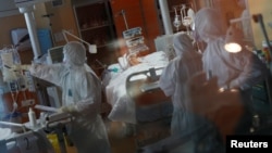 身着防护服的医务人员在意大利罗马的一家医院的重症监护病房治疗一名感染了新冠肺炎的病人。(2020年3月24日)