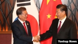 中国国家主席习近平与韩国总统文在寅在越南岘港出席亚太经合组织峰会时见面握手。(2017年11月11日)