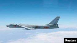 资料照:由日本空中自卫队2013年10月27日拍摄、日本防卫厅公布的照片显示,一架中国轰-6轰炸机从冲绳本岛和宫古岛之间的空域飞过。