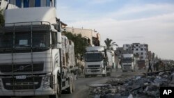 Sejumlah truk yang membawa bantuan kemanusiaan bergerak melalui perbatasan Kerem Shalom dari Mesir menuju Jalur Gaza, pada 19 Januari 2025. (Foto: AP/Jehad Alshrafi)