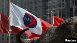 资料照:香港交易广场水牛雕塑前香港证券交易所的旗子在飘扬。(2015年5月28日)