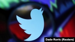 资料照 - 推特商标,背景是放大了的股市走势屏幕。