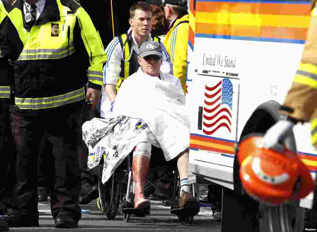 Một vận động viên bị thương được đẩy trên xe lăn sau vụ nổ bom ở Boston, Massachusetts, ngày 15/4/2013.