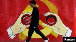 一名男子从上海街头中共党徽前走过。(2019年9月25日)