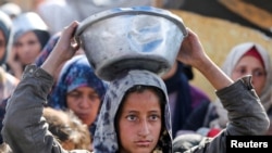 在哈马斯与以色列停火生效之前,巴勒斯坦人在加沙地带南部的汗尤尼斯聚集在一起,领取慈善厨房烹制的食物。(路透社:2025年1月17日)