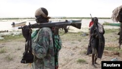 Một người đàn ông Turkana cầm một khẩu súng trường đứng trên bờ Hồ Turkana, gầnTodonyang ở phía bắc Kenya,25/9/2014.