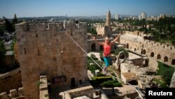 耶路撒冷老城,一位美国人在两座塔楼之间走绳索(资料图)