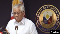A Filipino reacts as he is hit by waves along a promenade in Manila, Philippines, Sept. 14, 2014.