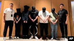 资料图片:在新华社发布的这张照片中,缅甸警方在仰光的仰光国际机场将五名电信和网络诈骗犯罪嫌疑人移交给中国警方。(2023年8月26日)