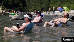 在热浪袭击下的加拿大不列颠哥伦比亚枫树岭,人们坐在艾鲁艾特湖中消暑。(2021年6月28日)