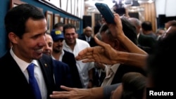 宣布自己为临时总统并得到多国承认的委内瑞拉反对派领袖瓜伊多在加拉加斯参加一次技术人员和专家的会议后问候民众。(2019年5月16日)