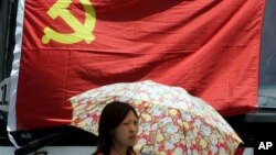 在上海,一名妇女在中共党旗下走过。中共有8000多万党员